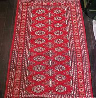 Full view of the red Bokhara wool rug showing overall design and layout