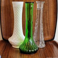 Three vases grouped: clear, white, green showing designs and relative sizes