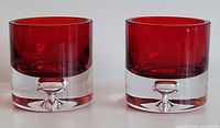 Both red glass votive holders front view