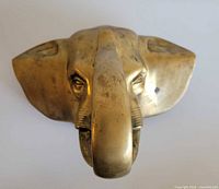 Front view of brass elephant head hanger showing form and patina