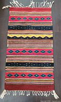 Full view of entire rug front showing pattern, colours and fringe