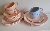stacks of pastel plates and cups showing quantity, colors and forms