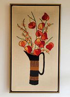 Front view of framed crewel embroidery depicting flowers in pitcher