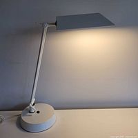 Full side view of white articulating lamp illuminated