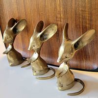 Front view of three brass mouse figurines