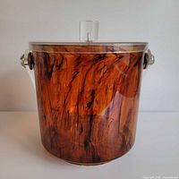 Front view showing amber tortoise acrylic body and clear lid knob