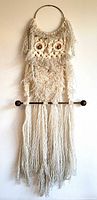 Full view of macramé owl wall hanging showing overall design and length