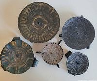 Overhead view of all five candle holders showing sizes, textures and central spikes