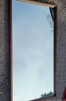 Front view showing full rectangular mirror with wood-tone frame