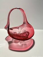 Front view of cranberry glass candy dish showing handle and base