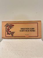 Front of wooden box showing First Nations fish graphic and bilingual smoked salmon text