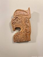 Full view of carved wood eagle plaque on wall