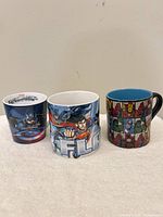 Front view of all three superhero mugs