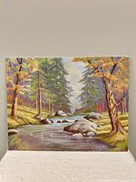 Front view of unframed fall landscape painting
