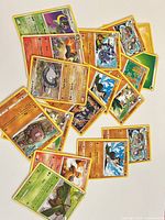 Scatter of 17 Pokémon cards on white surface