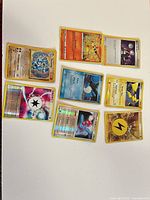 Group image of the eight holographic Pokémon cards laid out on white surface