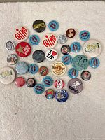Overview of all 34 pin-back buttons spread on towel