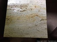 Top view of square marble table top showing natural beige and brown veining.