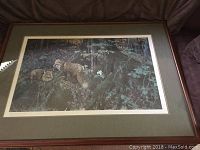 Framed numbered art print showing two red foxes in a forest environment with moss-covered tree roots and green leaves.