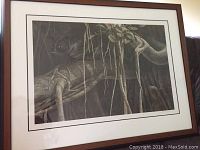 Framed and matted black and white print of a black panther perched on a tree branch in the jungle. The panther and tree detail are very fine. The frame is medium brown wood with a double beige matte.