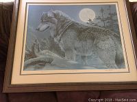 Full view of framed print showing a wolf under a full moon with surround mat and dark wood frame