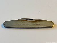 Full view of folded pocket knife showing engraving