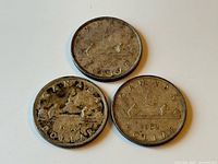 Three 1950s Canadian silver dollar coins reverse side