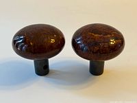Pair of polished brown porcelain Bennington-style door knobs on plain background