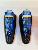 Front view of both blue pressed glass vases mounted on black plaques