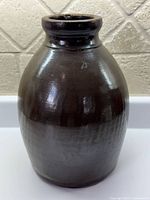 Front view of brown glazed stoneware crock
