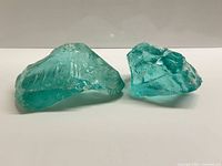 Two aqua slag glass chunks displayed side by side