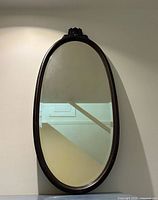 Full view of oval mirror hanging on wall
