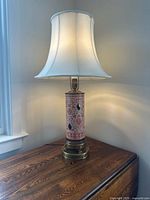Full view of porcelain lamp with shade on table
