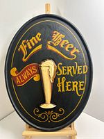 Front view of oval painted wood beer sign