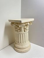 Angled left view of plaster pedestal showing fluted shaft and decorated capital