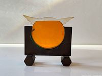 Front view of bronze frame with orange acetate photo window and winged crest