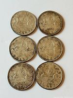 Front faces of six Canadian silver dollars laid out in two columns