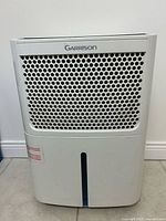 Front view of Garrison dehumidifier showing grille and water level indicator