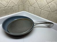 Henkel frying pan and mesh splatter guard nested together