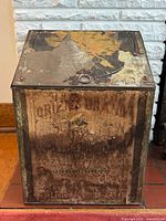 Front view of antique tea tin showing faded graphics and overall condition