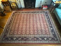 Full view of rug on floor showing overall pattern and borders