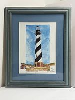 Framed lighthouse print in blue mat and wood frame