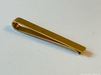 Top angled view of gold tie clip
