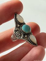 Front view showing turquoise and mother-of-pearl stones with decorative silverwork
