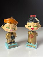 Front view of both bobblehead kissing dolls on bases