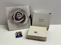 Front view of presentation folder with rose image, silver proof coin outer box, inner clamshell box, and royal wedding matchbook