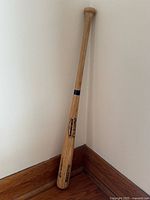 Full view of Rawlings wooden baseball bat leaning in corner