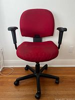 Front view of red office chair showing overall design, black base and armrests