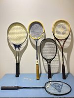 Six racquets displayed upright and flat on table