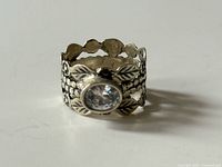 Front view of sterling silver ring showing bezel-set stone and decorative band